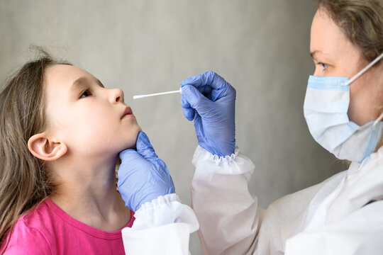 COVID-19 PCR test and kid, nurse holds swab for nasal sample from adorable child