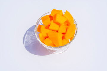 Cantaloupe fresh melon cubes in glass bowl on beige background. Organic vegetarian healthy food. Diet dessert fruit.