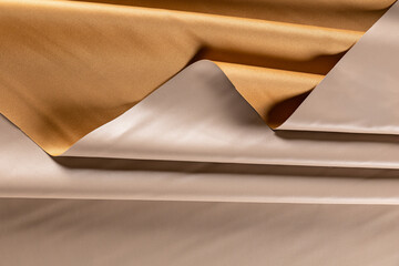 surface with folds of artificial leather for sewing light beige clothes