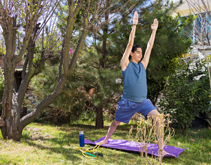young man doing yoga positions in a garden