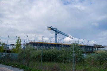 Grua de la construcción con edificios y cielo de fondo