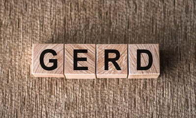 Fototapeta premium GERD word written on wooden blocks on a brown background.