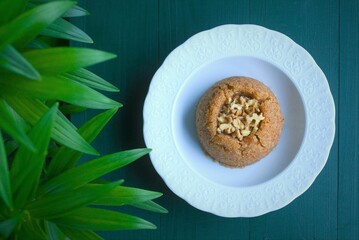 Semolina halva with walnuts in a white porcelain plate