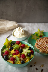 Fresh healthy fruit salad blue green cup on white background with carambola