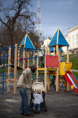 Mom with a little daughter on the playground