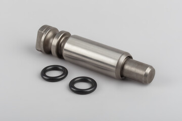 The repair kit for the spring from the pin bushing and gaskets lies on a gray background. Bushing and finger for truck repair. automotive components for heavy vehicles