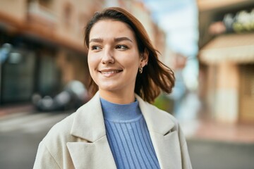 Obraz premium Young hispanic woman smiling happy standing at the city