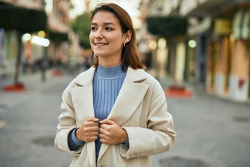 Young hispanic woman smiling happy standing at the city