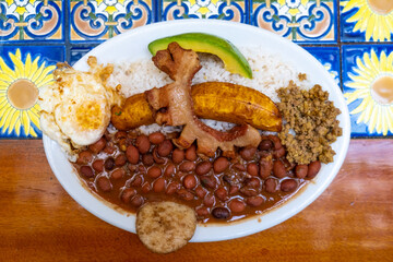 Bandeja paisa, typical dish at the Antioqueña region of Colombia. It consists of chicharrón (fried pork belly), black pudding, sausage, arepa, beans, fried plantain, avocado egg, and rice