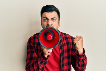 Hispanic man with beard screaming with megaphone