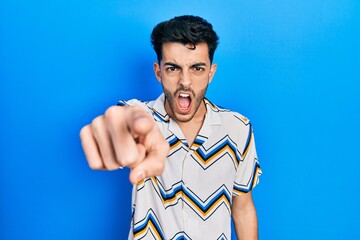 Young hispanic man wearing casual clothes pointing displeased and frustrated to the camera, angry...