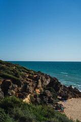 Fototapeta na wymiar Playa con barranco rocoso y el mar de fondo