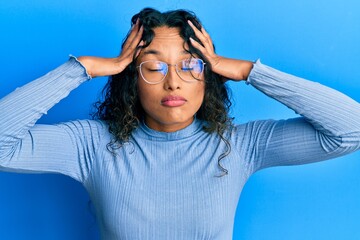 Young latin woman wearing casual clothes and glasses with hand on head, headache because stress. suffering migraine.