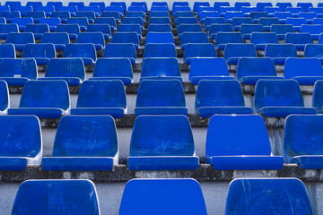 Gradas de estadio de futbol modesto con asientos de color azul