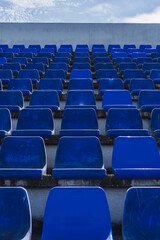 Gradas de estadio de futbol modesto con asientos de color azul