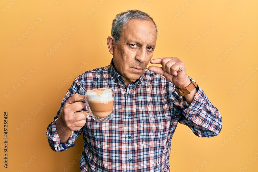 Poster Handsome senior man with grey hair drinking a cup coffee mouth and lips shut as zip with fingers. secret and silent, taboo talking