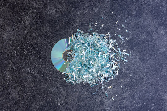 ganze und zerstörte DVD oder CD auf schwarzem Tisch