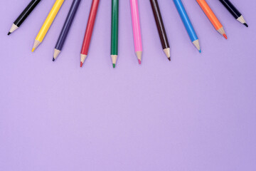 Obraz premium Colored pencils for drawing. Lilac background with pencils.