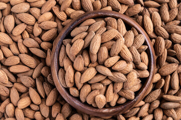 Almonds in wooden bowl top view