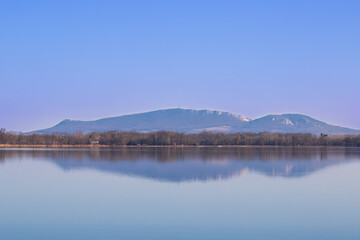 Calm water of the Vrkoc pond. In the background are the hills of Palava. Beautiful landscape in the Czech Republic in Europe.