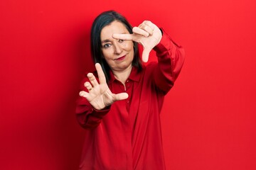 Middle age hispanic woman wearing casual clothes doing frame using hands palms and fingers, camera perspective