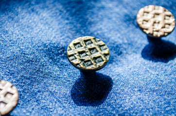 macro close up of buttons on denim textile indigo blue cotton