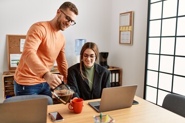 Two caucasian business executives working and drinking coffee at the office.