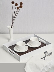 Coffee on breakfast tray.White wooden tray with cups
