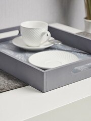 Coffee on breakfast tray. Grey wooden tray with cups