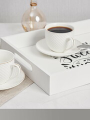 Coffee on breakfast tray.White wooden tray with cups