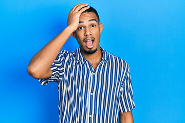 Naklejka premium Young african american man wearing casual clothes surprised with hand on head for mistake, remember error. forgot, bad memory concept.