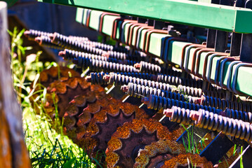 Obraz premium A close up of a seed drill on a small farm with rows of disc and springs. 