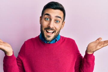 Young hispanic man wearing casual clothes smiling showing both hands open palms, presenting and advertising comparison and balance