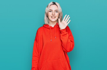 Fototapeta premium Young blonde girl wearing casual clothes showing and pointing up with fingers number five while smiling confident and happy.