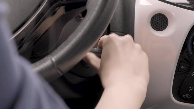 Starting car engine. a woman's hand sliding keys into car switch starting the engine.  Igniting car. The driver inserts the ignition key into the ignition lock, turns it and starts engine