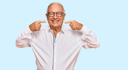 Senior caucasian man wearing business shirt and glasses smiling cheerful showing and pointing with fingers teeth and mouth. dental health concept.