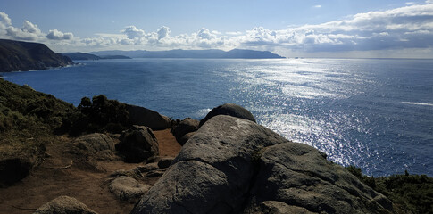 blue sea on rocky coast with clouds