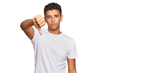 Young handsome african american man wearing casual white tshirt looking unhappy and angry showing rejection and negative with thumbs down gesture. bad expression.