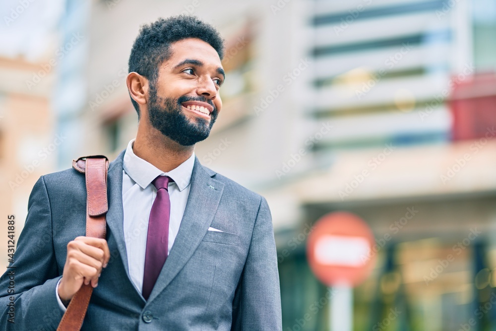 Poster Young african american businessman smiling happy standing at the city.