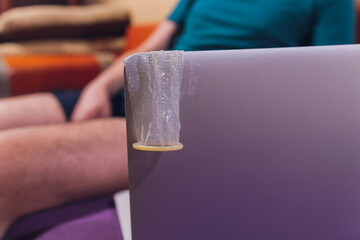 Cybersex, internet dating concept. A condom package on top of a laptop keyboard.
