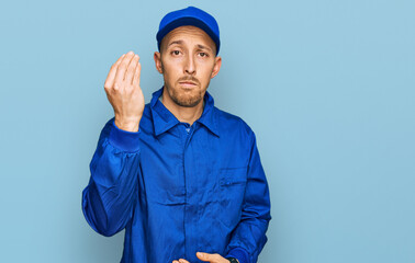 Bald man with beard wearing builder jumpsuit uniform doing italian gesture with hand and fingers confident expression