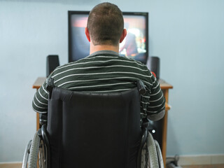 Disabled guy watching movie on computer at home during lockdown time,medical tech