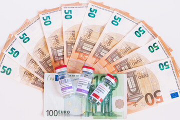 Three different vaccines to fight the coronavirus pandemic. The huge amount of money the European Union is spending. Euro banknotes, business with vaccines. Concept of treatment and cost.