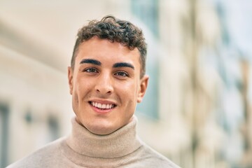 Young hispanic man smiling happy standing at the city.