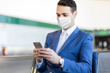 Businessman using the phone at the airport, covid concept