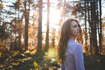 Young, brunette girl in the forest, looking at something