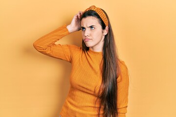 Young brunette teenager wearing casual yellow sweater confuse and wondering about question....