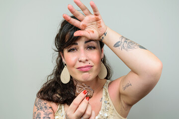 Tattooed woman, looking at the camera, with her hand on her head and sorry that she ate a Brazilian...