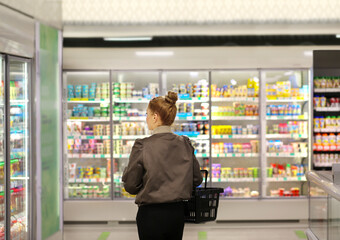 Woman choosing frozen food from a supermarket freezer