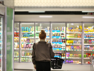Woman choosing frozen food from a supermarket freezer